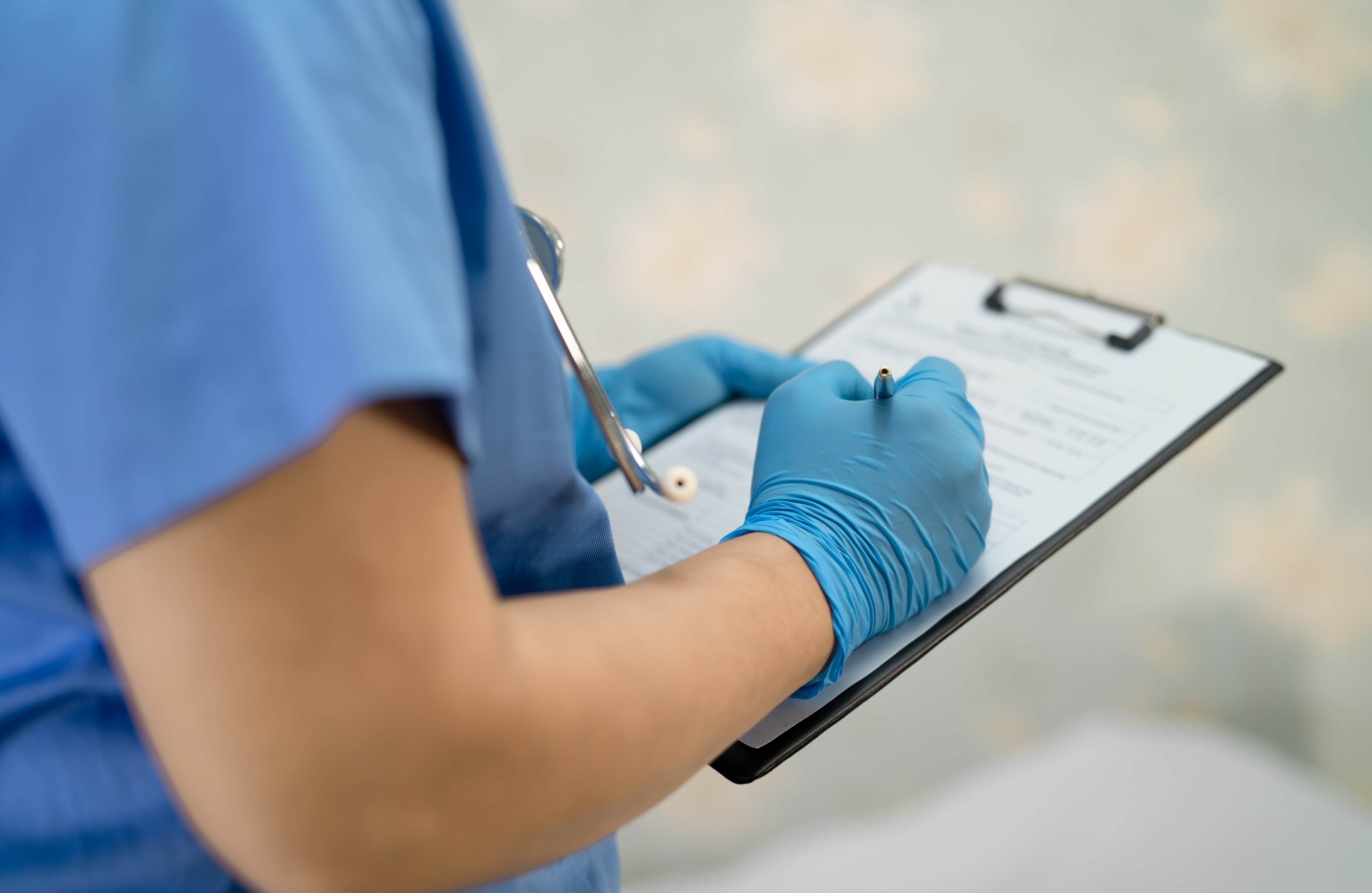Nurse writing on a patient record