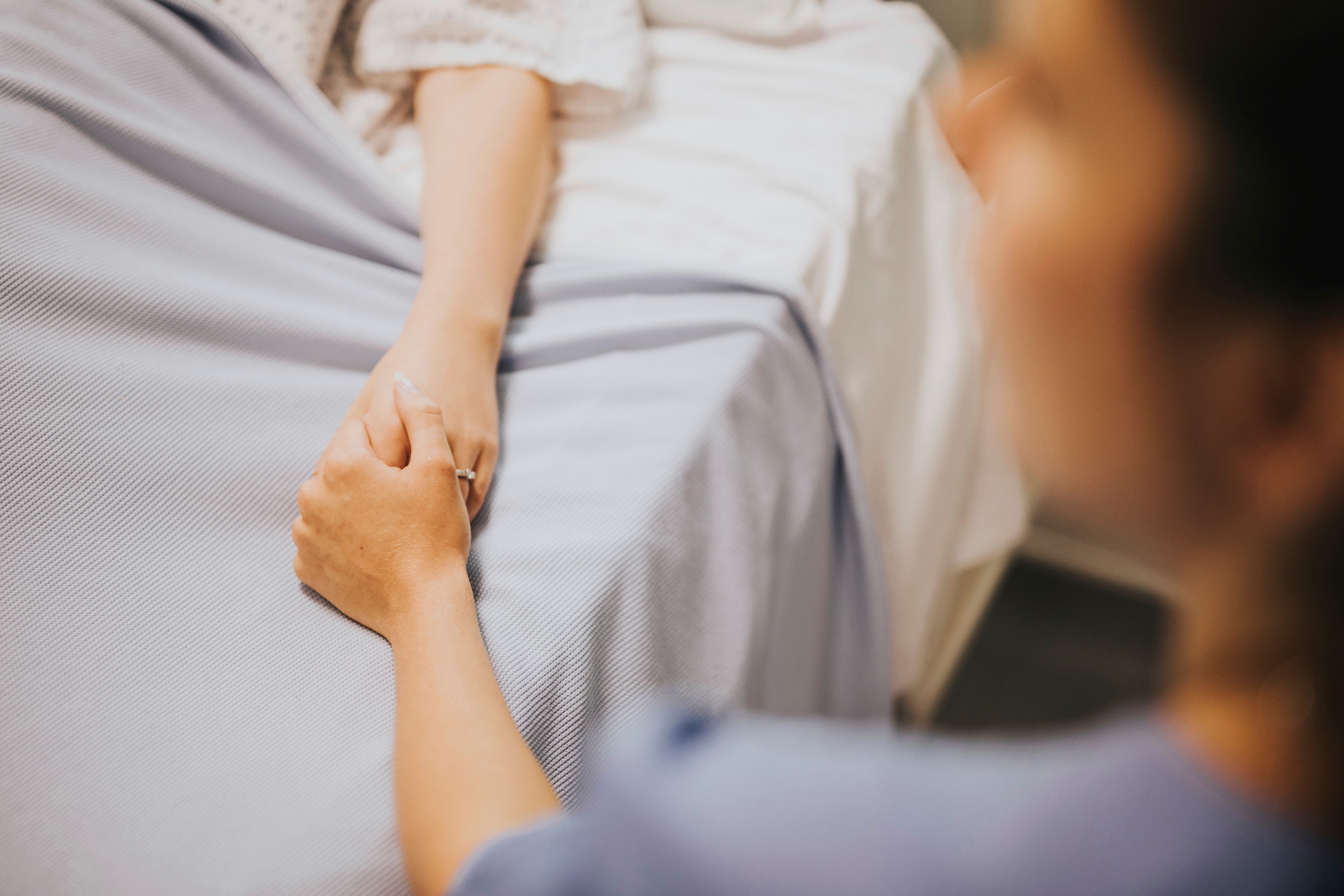 Nurse holding patients hands