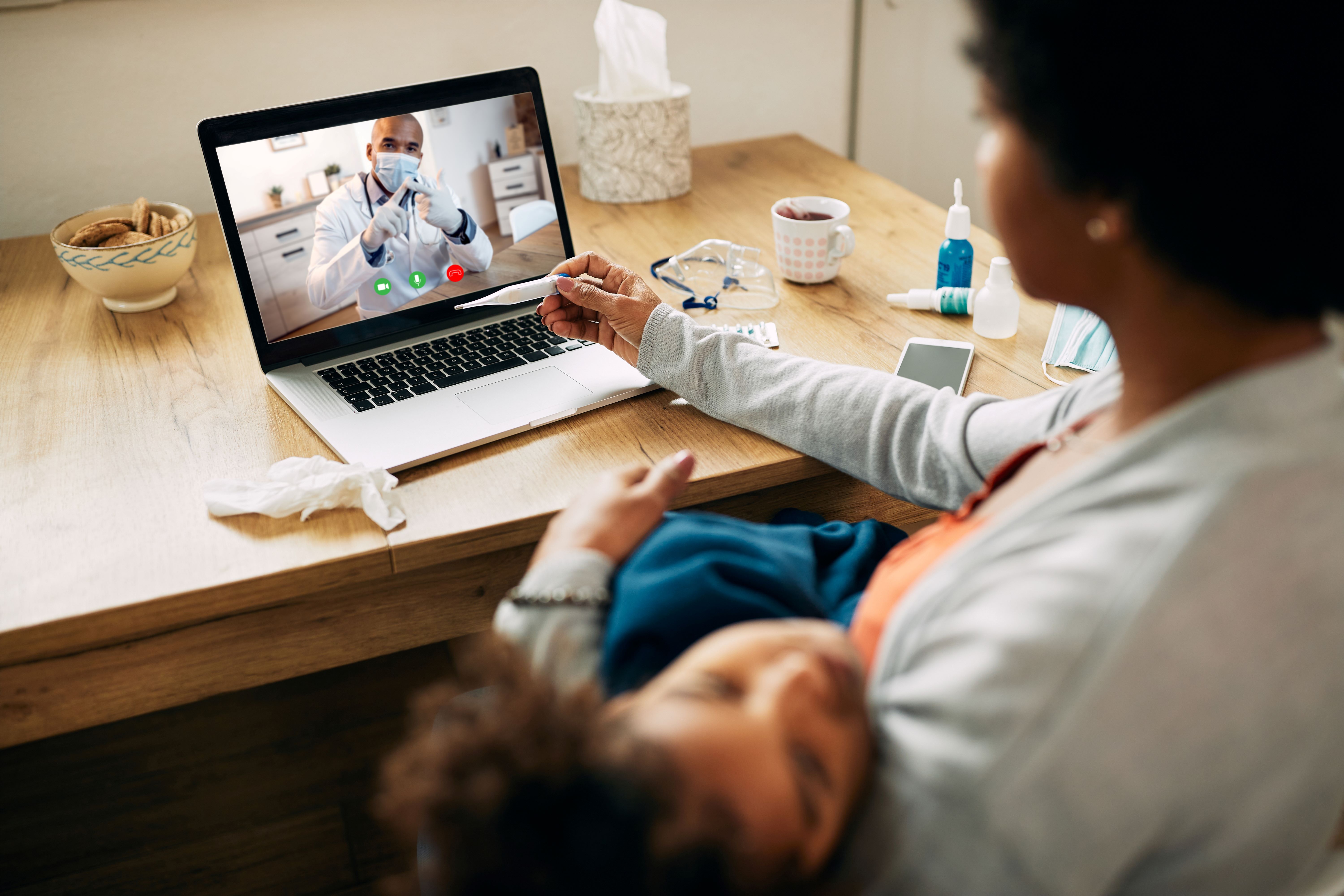 closeup-mother-having-video-call-with-pediatrician-while-measuring-daughter-s-temperature-home