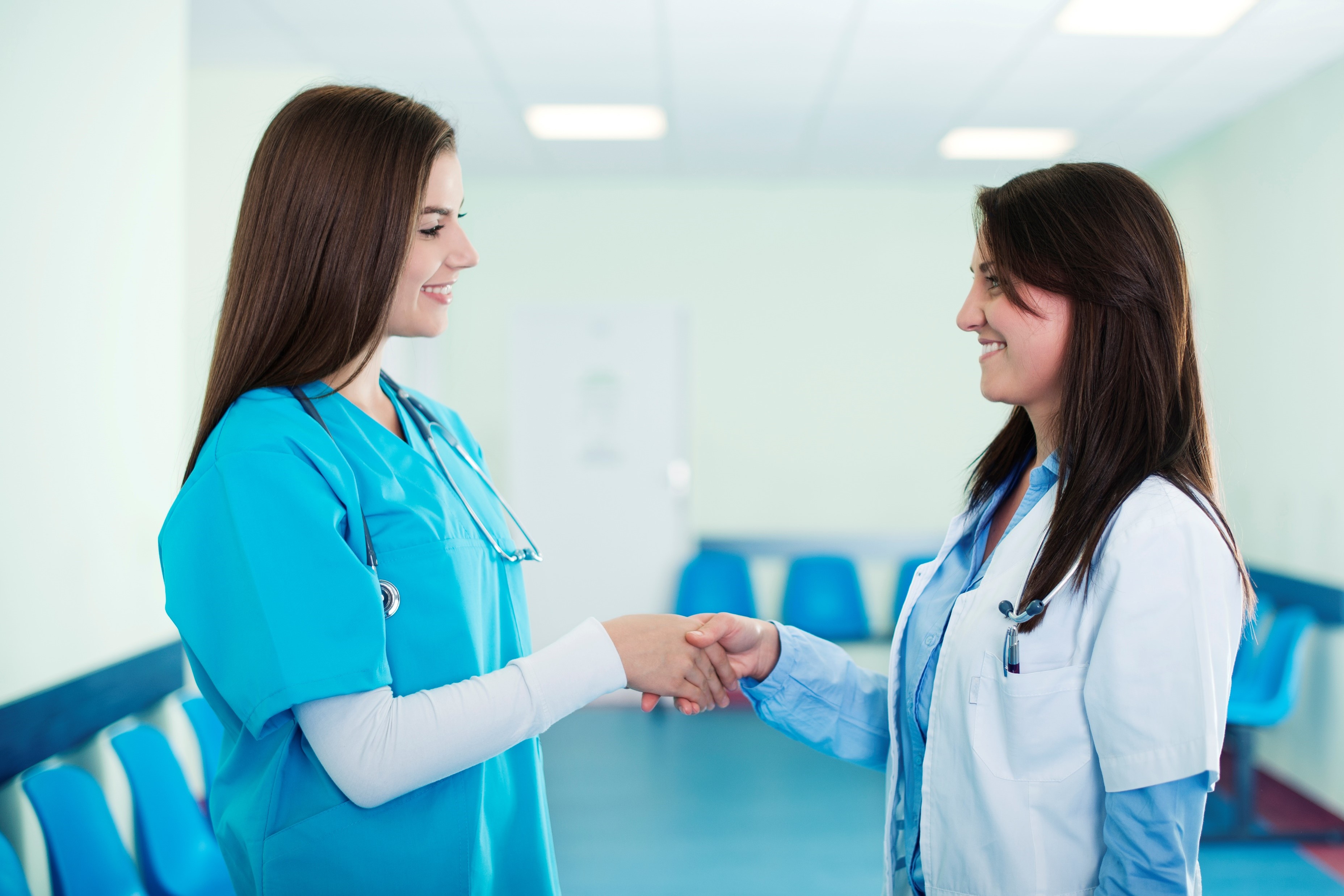 Doctor and nurse talking and shaking hands in the hospital