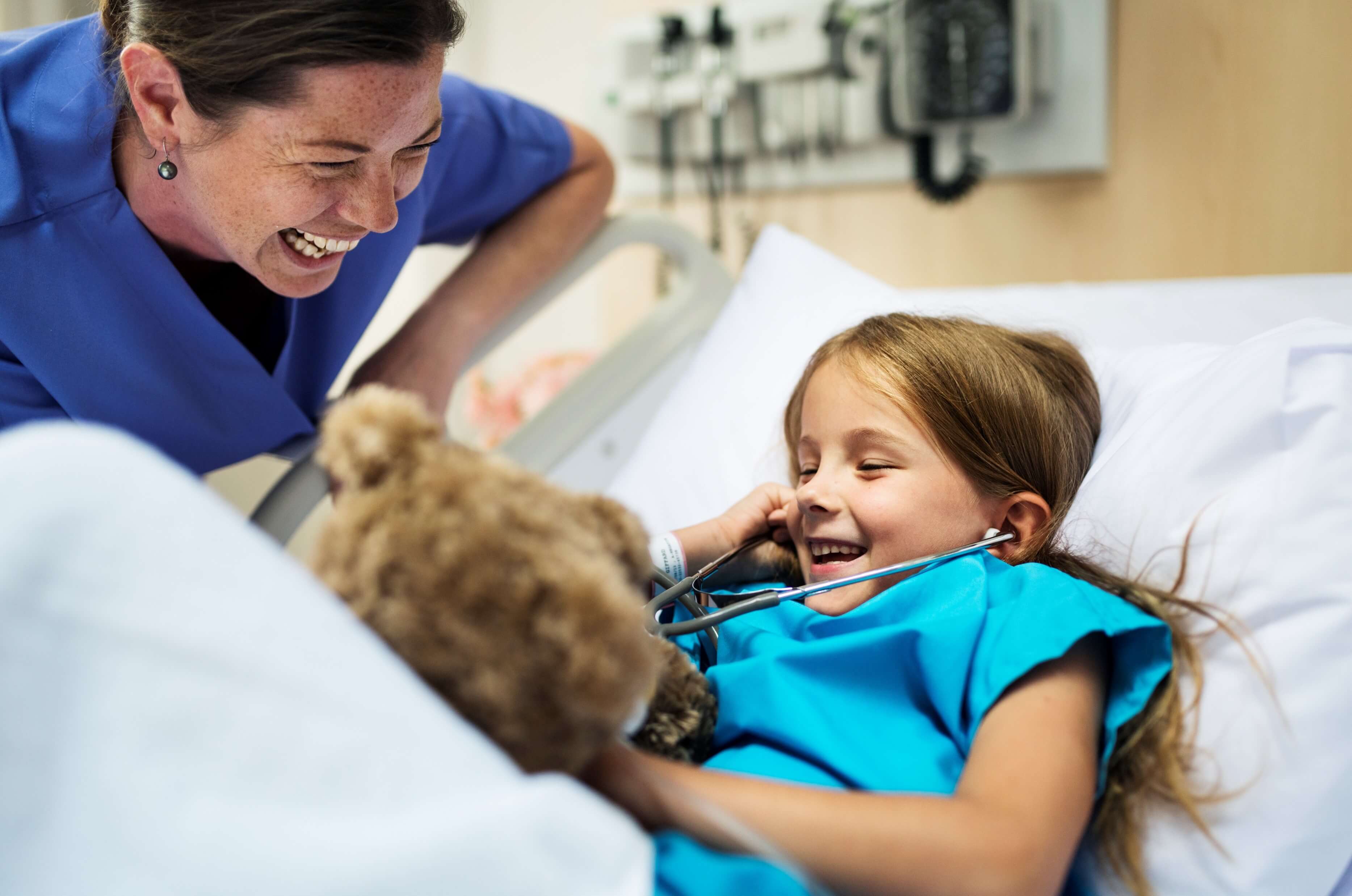 little patient girl smiling with the pediatric nurse
