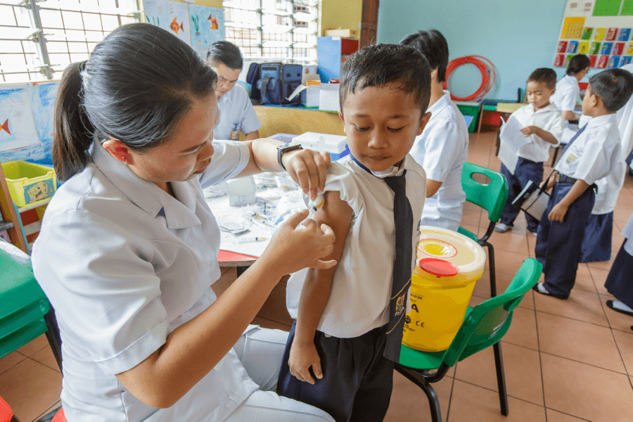 Nurse administering vaccine to a kid