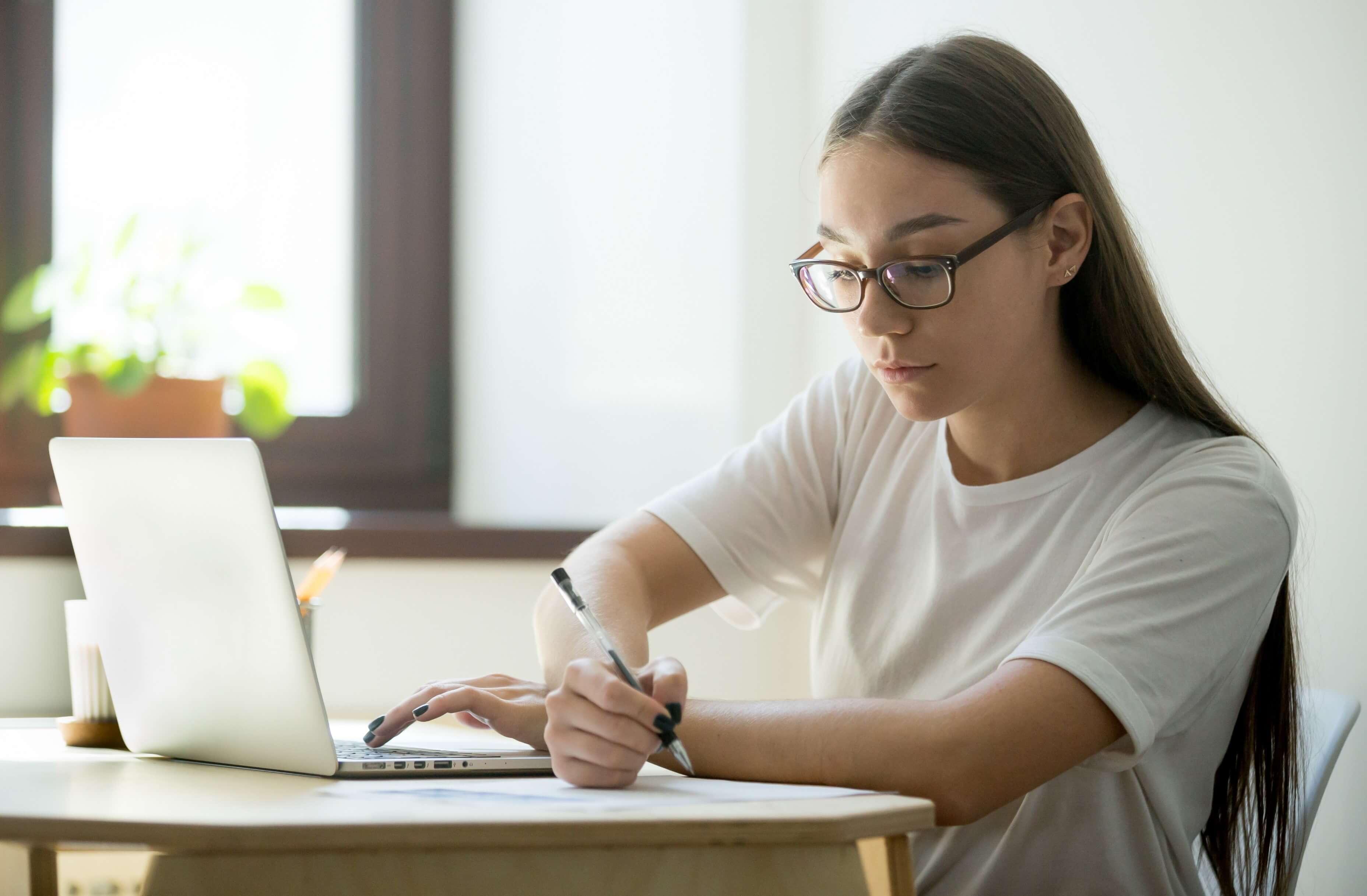 Student taking exams - writing with laptop