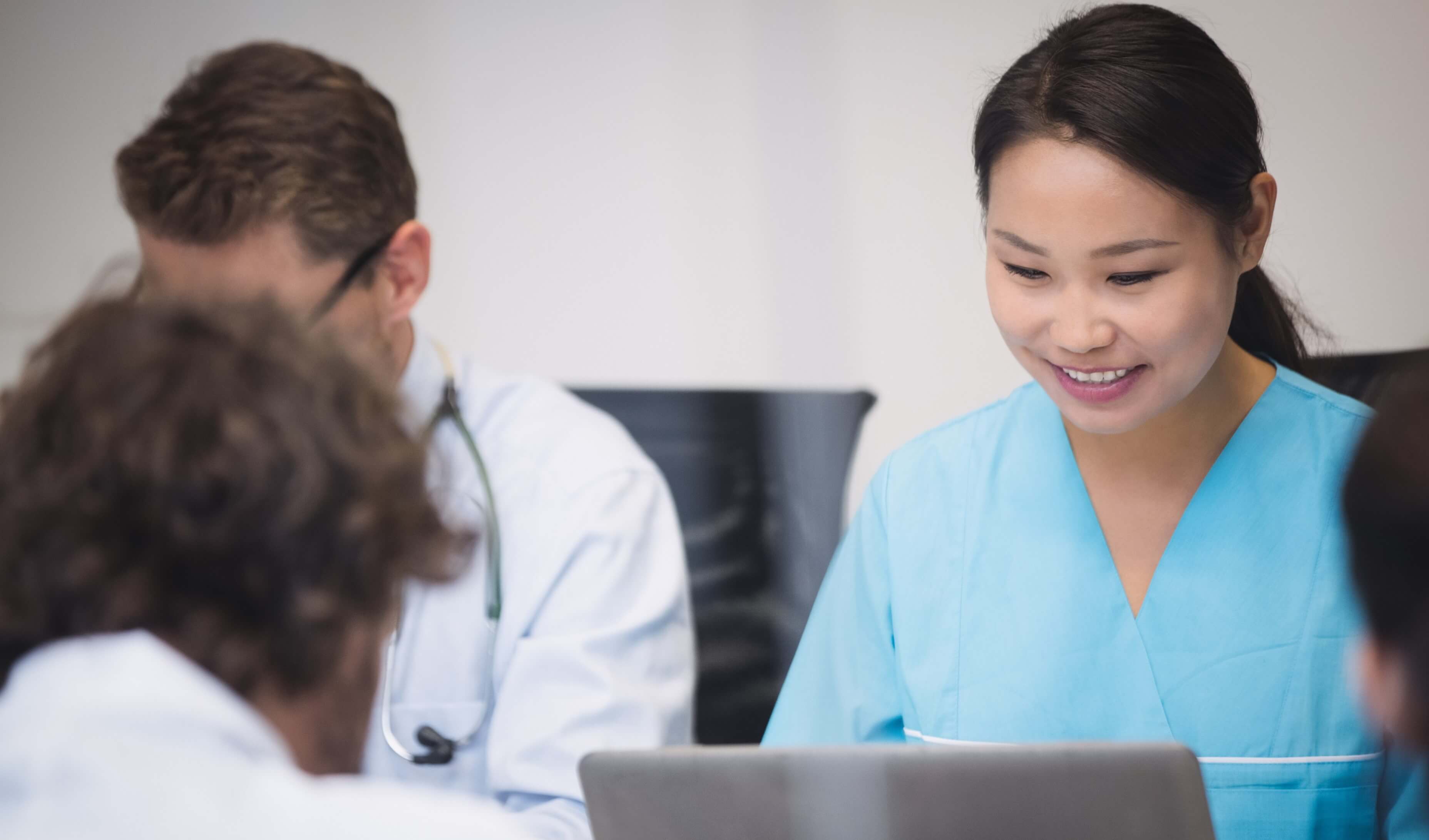 Nurse Smiling facing laptop