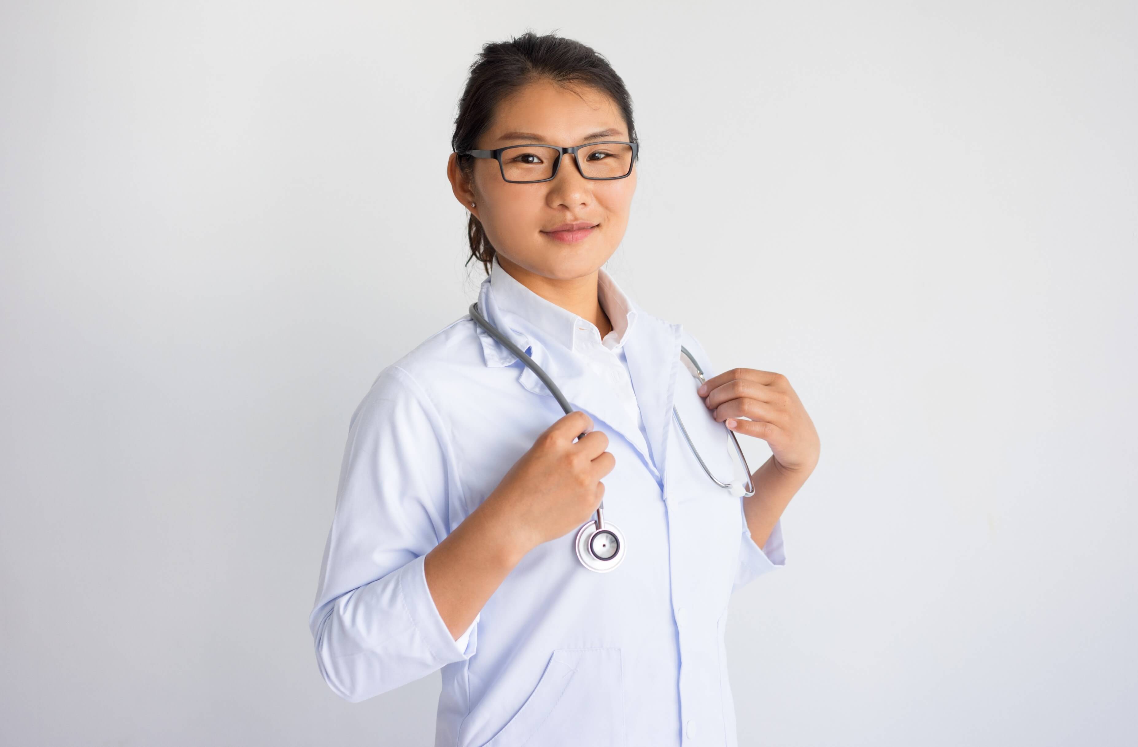 Pretty young smiling asian doctor-nurse holding a stethoscope