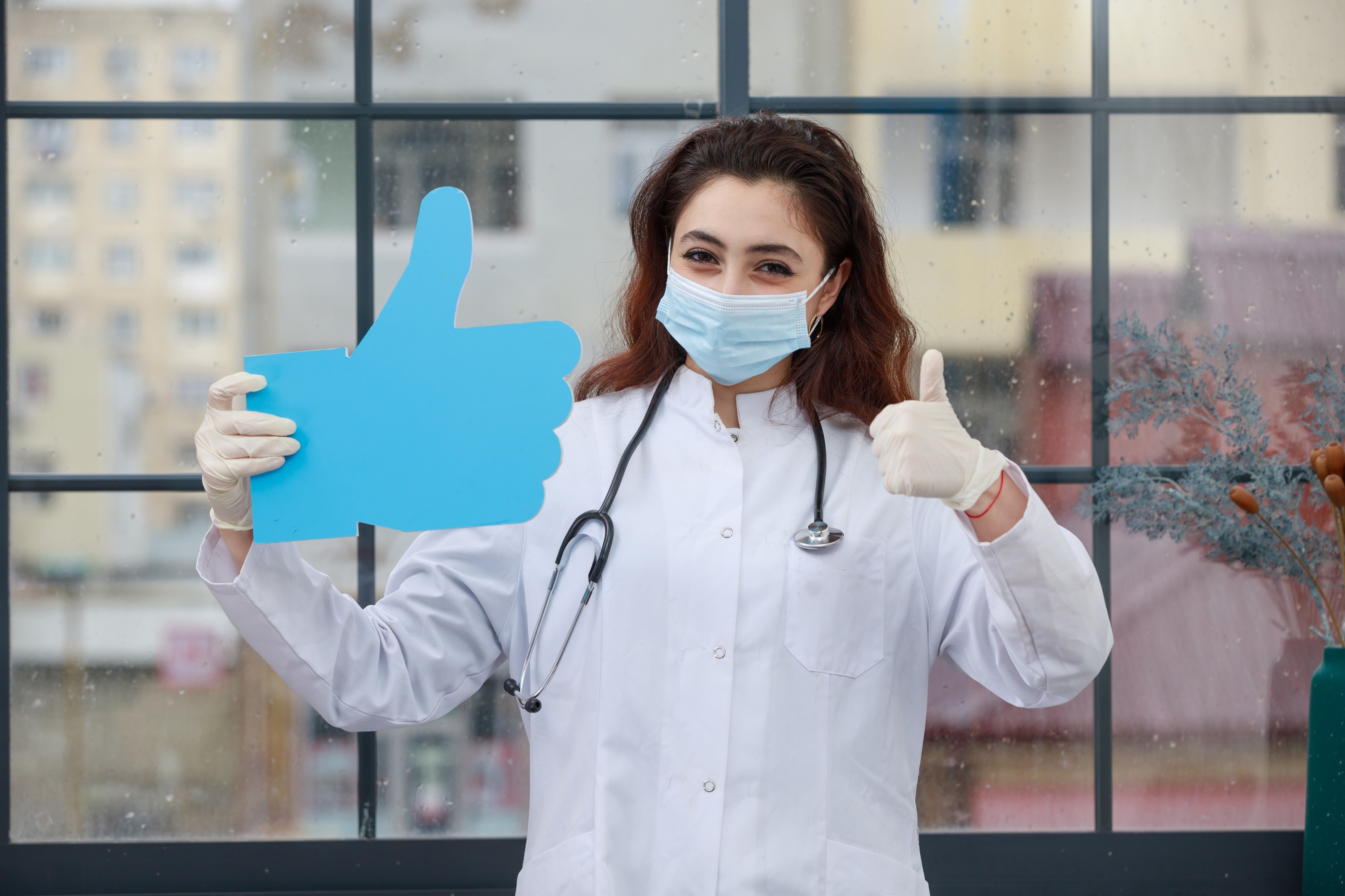 young-doctor-holding-paper-idea-bubble-thumb-up-shape-smiling-high-quality-photo